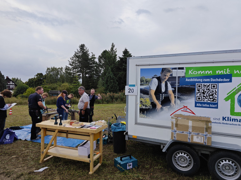 Dachdecker-1: Infostand zur Ausbildung zum Dachdecker mit Teilnehmern und Werkzeugen Dachdecker-Ausbildung Infostand mit Werkzeugen und Teilnehmern im Freien