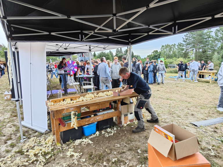 Tischler arbeitet an Werkbank auf Messe oder Event im Freien Tischler bei der Arbeit an einer Werkbank auf einer Messe oder Veranstaltung im Freien