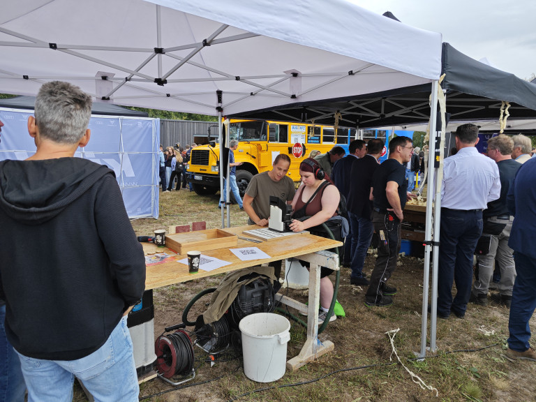Tischler demonstrieren ihr Handwerk auf einer Outdoor-Veranstaltung Tischler bei der Arbeit auf einer Messe oder Veranstaltung im Freien unter einem Pavillon
