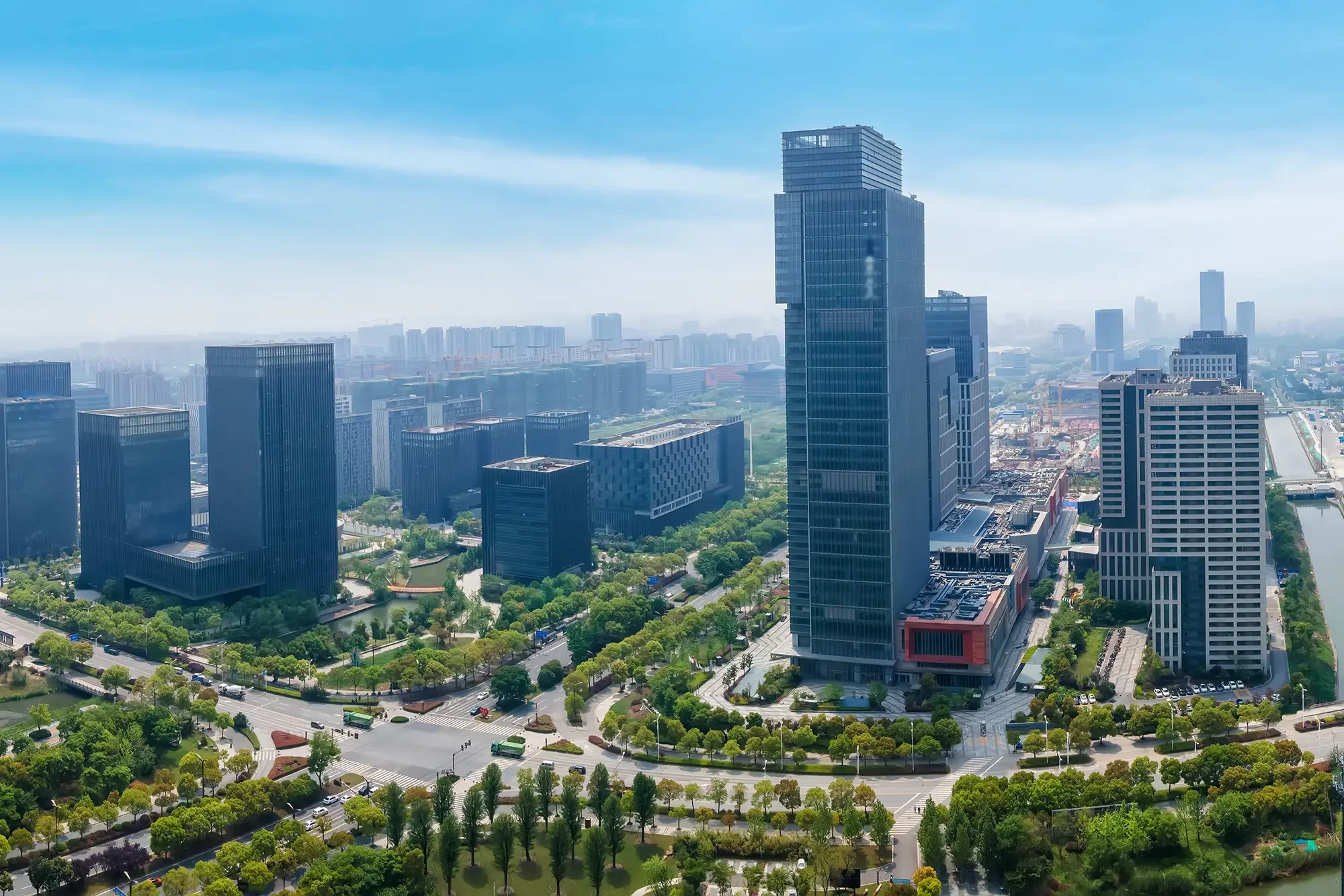 Moderne Skyline mit Bürogebäuden und viel Grün am Standort