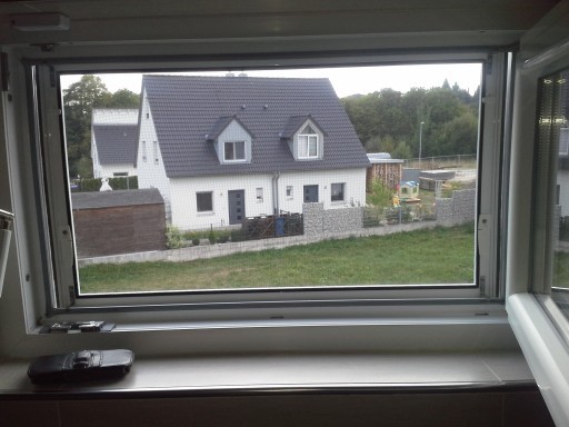 Insektenschutz am Fenster – effektiver Schutz vor Insekten mit Ausblick auf Einfamilienhaus Insektenschutz am Fenster mit Blick auf ein Einfamilienhaus und Garten