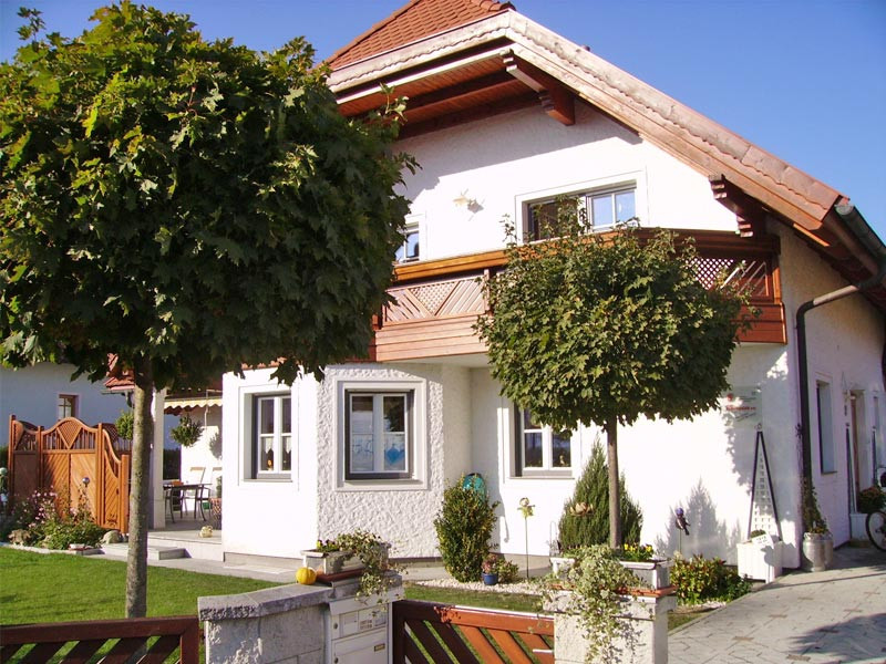 Haus mit neuen Fenstern nach Renovierung, Vorderansicht mit Garten