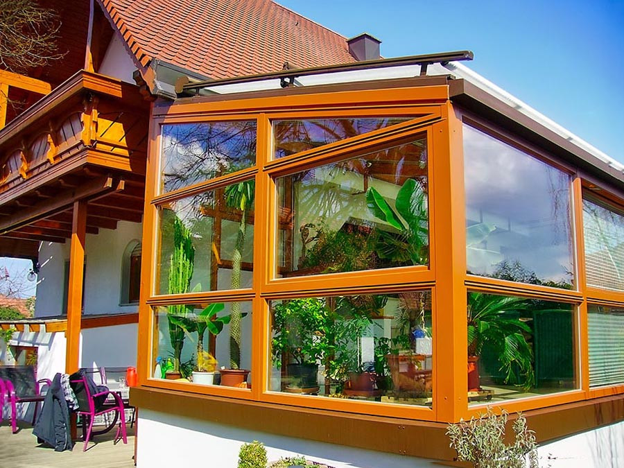 Moderner Wintergarten nachher mit großen Glasflächen und vielen Pflanzen