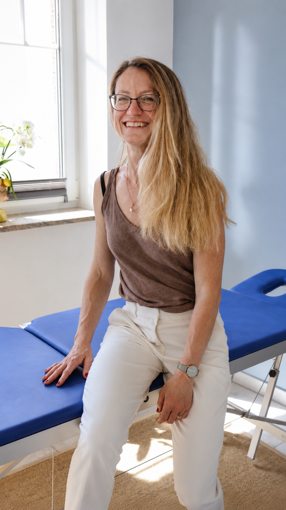 Ina Broermann, Heilpraktikerin für TCM in der Region Schönebeck, sitzt auf einer Behandlungsliege in ihrer Praxis.