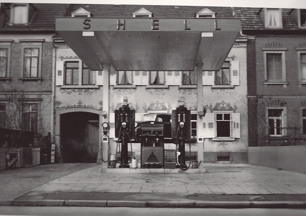 Die umgebaute Tankstelle mit Betonvordach und SHELL-Schriftzug über zwei Säulen