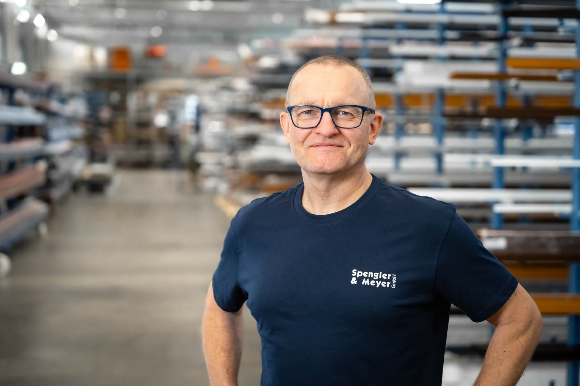 Mitarbeiter in einer Lagerhalle mit blauem T-Shirt von Spengler & Meyer GmbH
