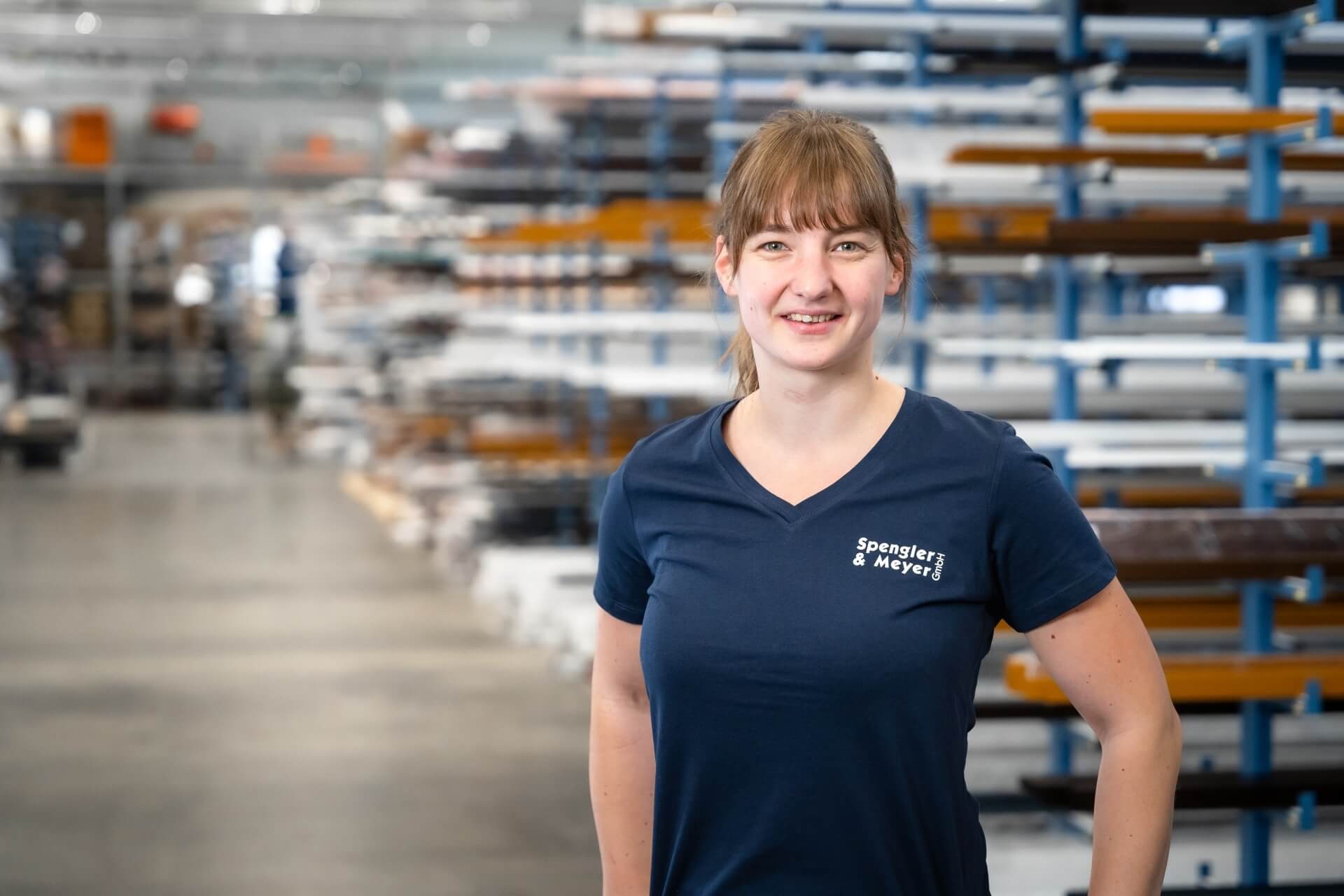 Mitarbeiterin im Lager von Spengler & Meyer GmbH mit Regalen im Hintergrund