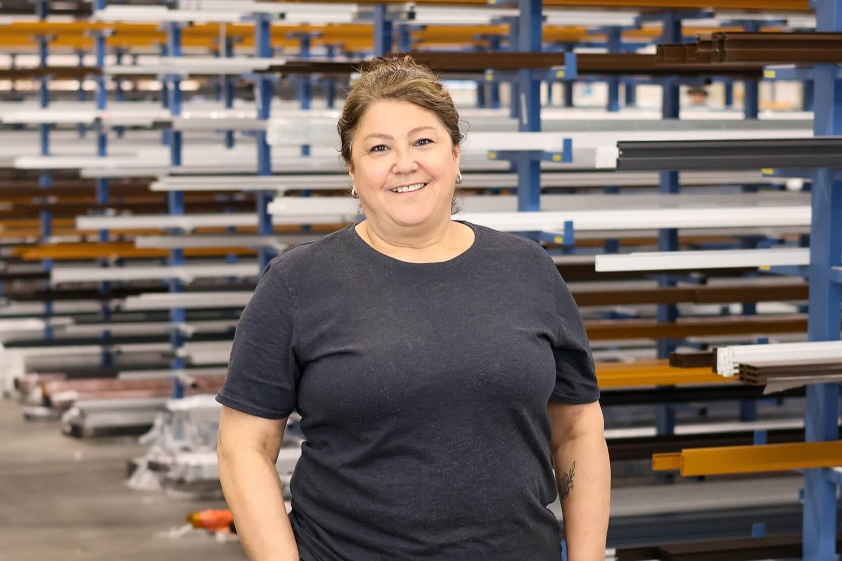 Frau in einem industriellen Lager mit Regalen im Hintergrund