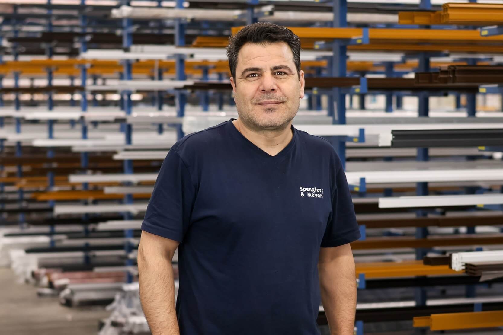 Arbeiter in einer Werkstatt vor Aluminiumprofilen