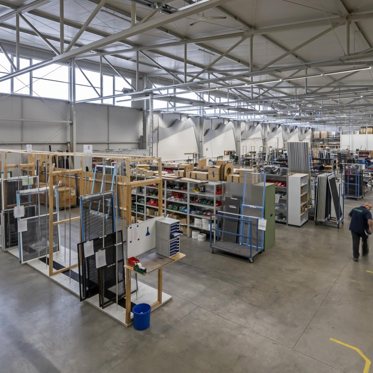Moderne Fertigungshalle mit Produktionsmaterialien und Regalen in einer industriellen Umgebung