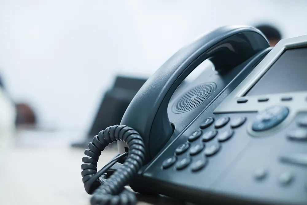 Kontakt – Nahaufnahme eines modernen Festnetztelefons im Büro