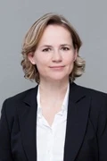 Portrait von Alexandra Werner im Business-Outfit vor grauem Hintergrund