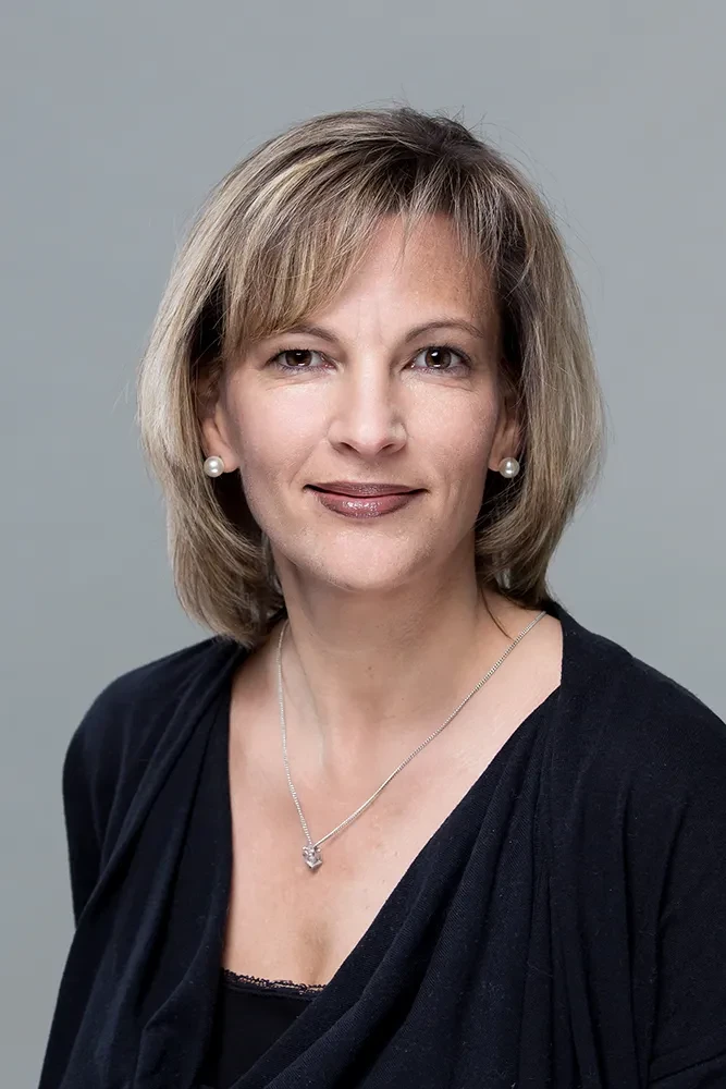 Portrait von Melanie Grotjahn vor grauem Hintergrund