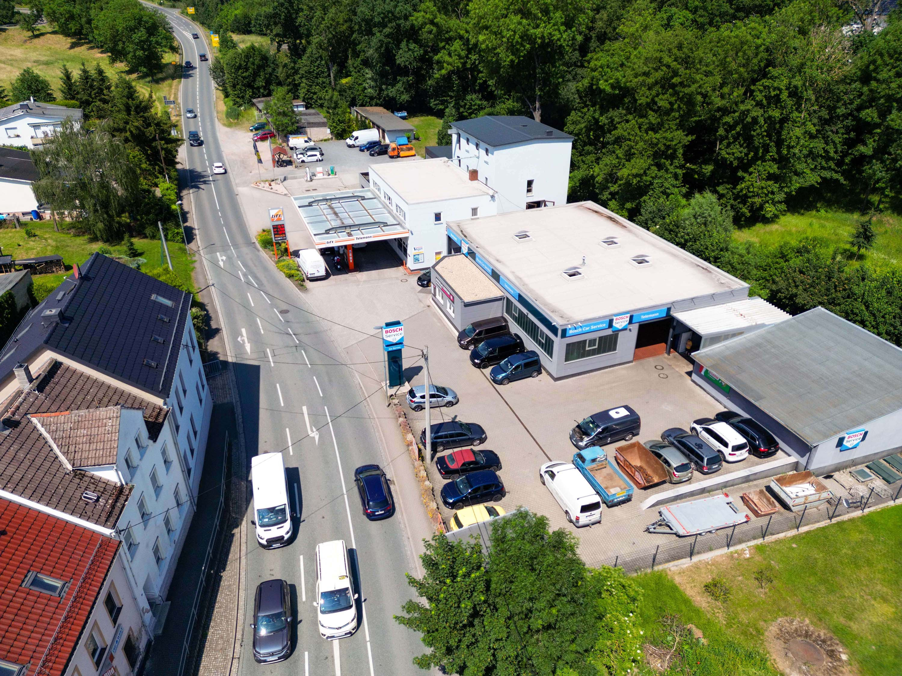 Luftaufnahme einer Bosch Autowerkstatt mit mehreren Fahrzeugen und angrenzender Straße