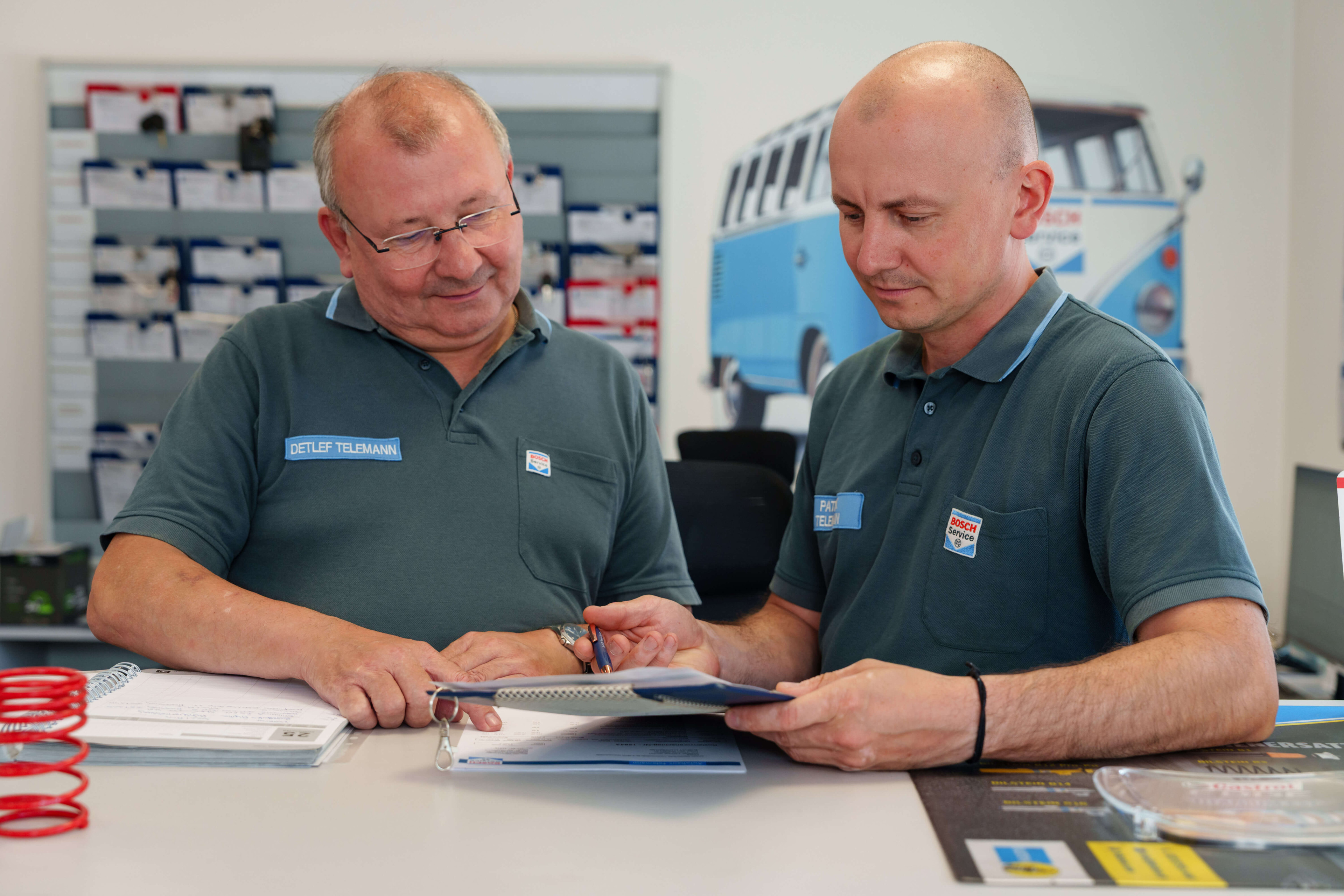 Zwei Mitarbeiter bei Bosch Service Telemann im Beratungsgespräch am Tresen
