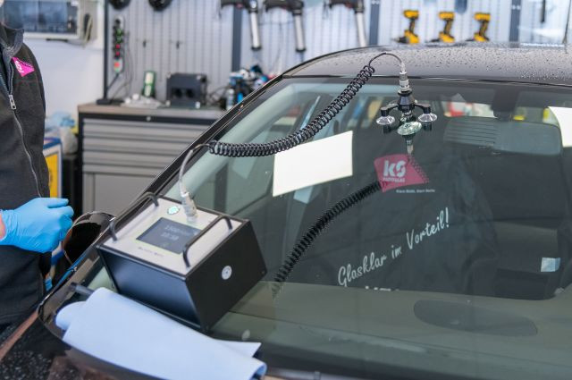 Autoglas Steinschlagreparatur mit Spezialgerät an einer Windschutzscheibe