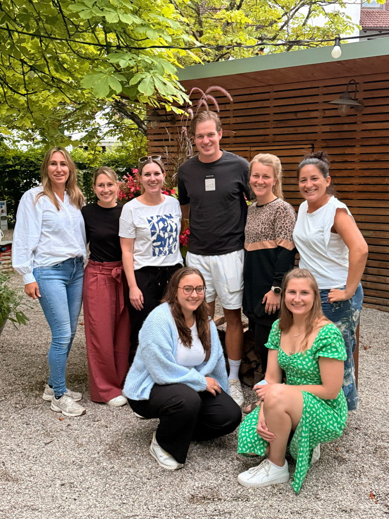 Damen 2026 Gruppenfoto – Teamfoto im Garten vor Holzhaus Gruppenfoto Damen 2026, Teamfoto im Freien vor Holzhaus