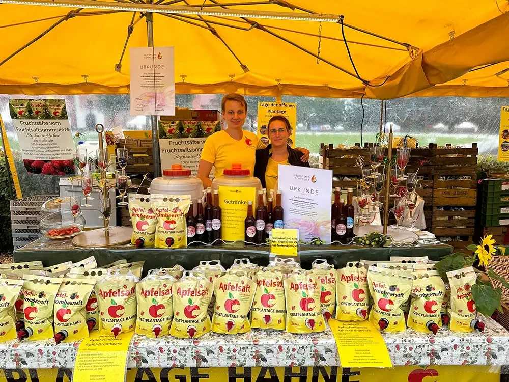 Verkaufsstand der Obstplantage Hahne mit Apfelsaft und Fruchtsäften auf einem Markt