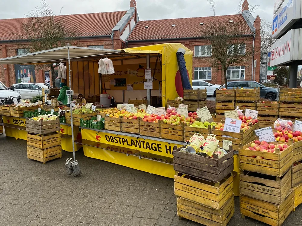 Frischer Apfelstand auf dem Markt – Obstplantage Hahne präsentiert regionale Produkte Obststand auf dem Wochenmarkt mit frischen Äpfeln und Säften von der Obstplantage Hahne
