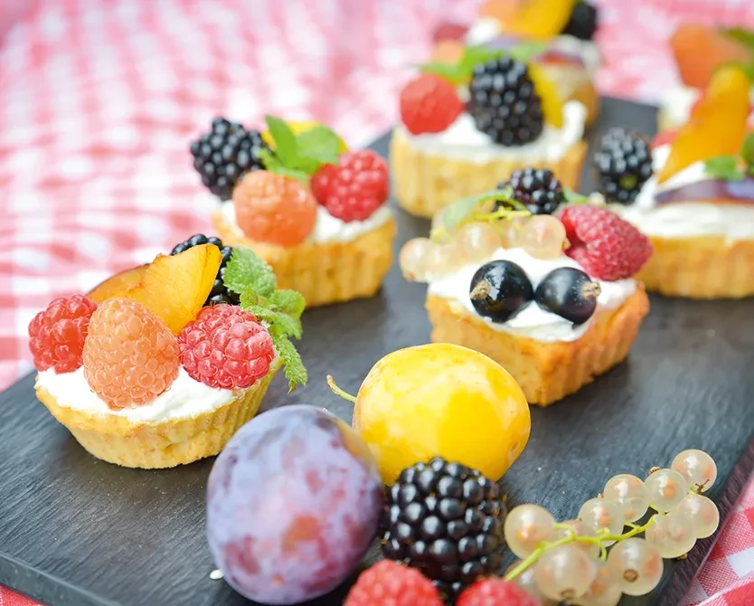 Fruchtige Obsttörtchen mit frischen Beeren und Pflaumen aus der Obstplantage Hahne