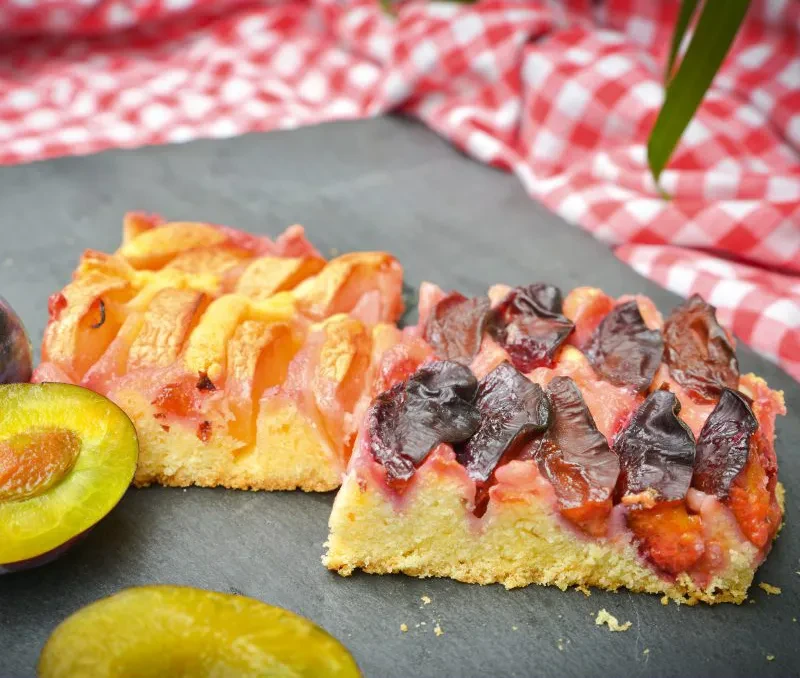 Apfel-Zwetschgen-Kuchen – frischer Blechkuchen mit Äpfeln und Zwetschgen Apfel-Zwetschgen-Kuchen auf einem Teller, Nahaufnahme von zwei Kuchenstücken mit Äpfeln und Zwetschgen