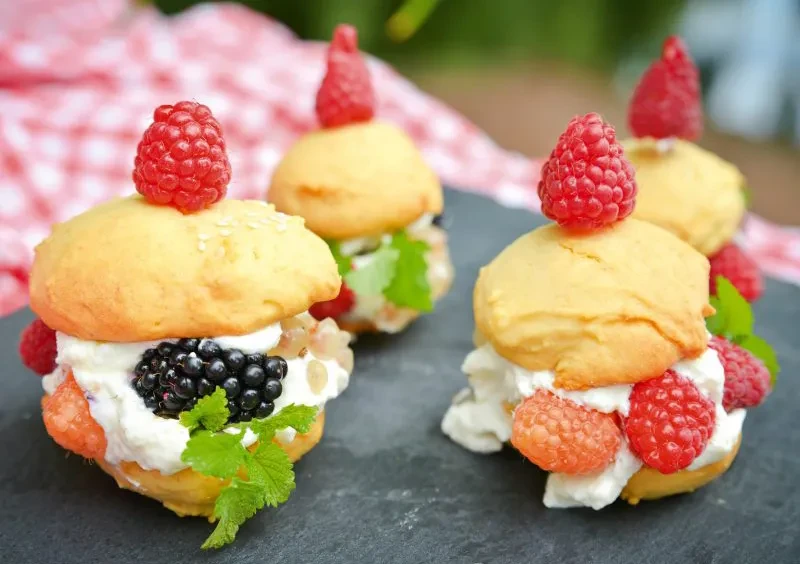 Beeren-Burger Rezept – kreative Burger mit Himbeeren, Brombeeren und Sahne Beeren-Burger mit frischen Himbeeren, Brombeeren und Sahne auf einem Schieferbrett serviert