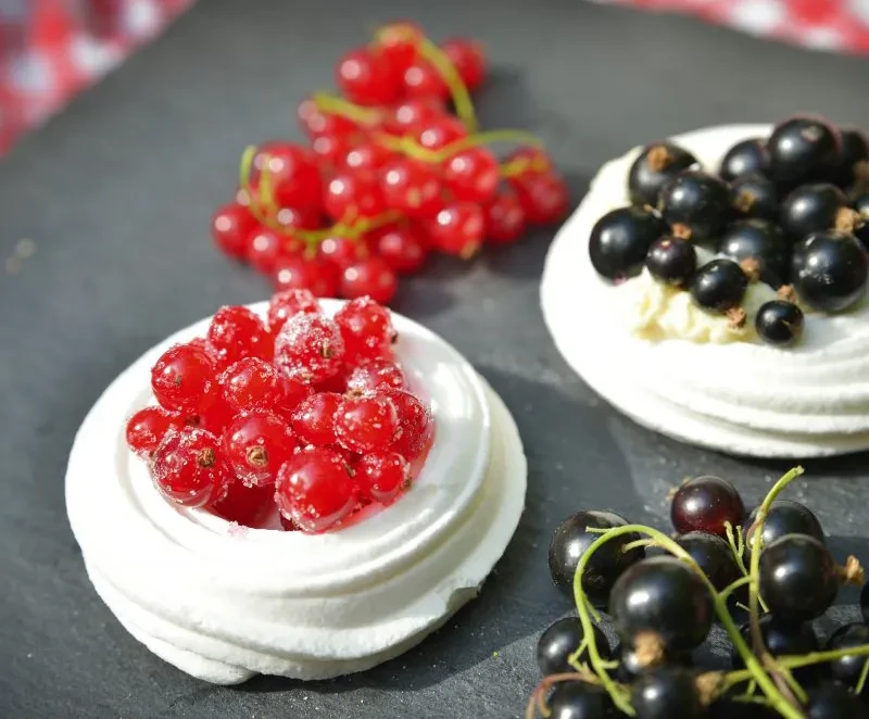 Beeren-Baiser Dessert mit roten und schwarzen Johannisbeeren Beeren-Baiser mit frischen roten und schwarzen Johannisbeeren auf Schieferplatte