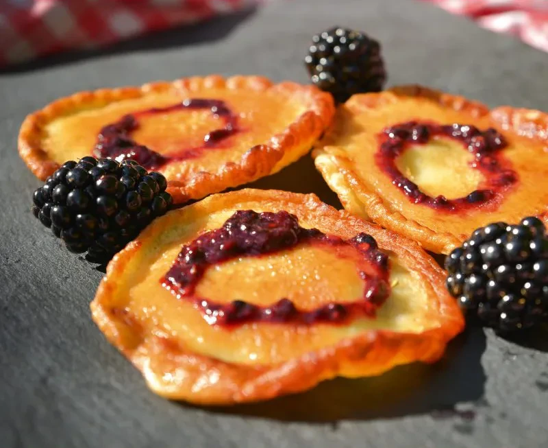 Brombeer-Pfannkuchen mit frischen Brombeeren – Rezept und Genussidee Drei Brombeer-Pfannkuchen mit frischen Brombeeren auf einer Schieferplatte