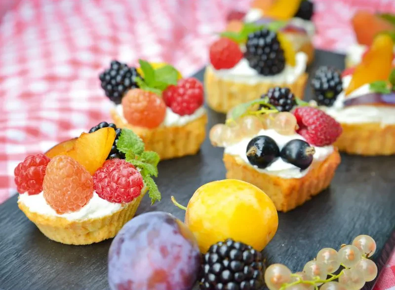 Kleine Beerentörtchen mit frischen Beeren und Obst – Rezept und Inspiration Kleine Beerentörtchen mit frischen Beeren und Obst auf einer Platte