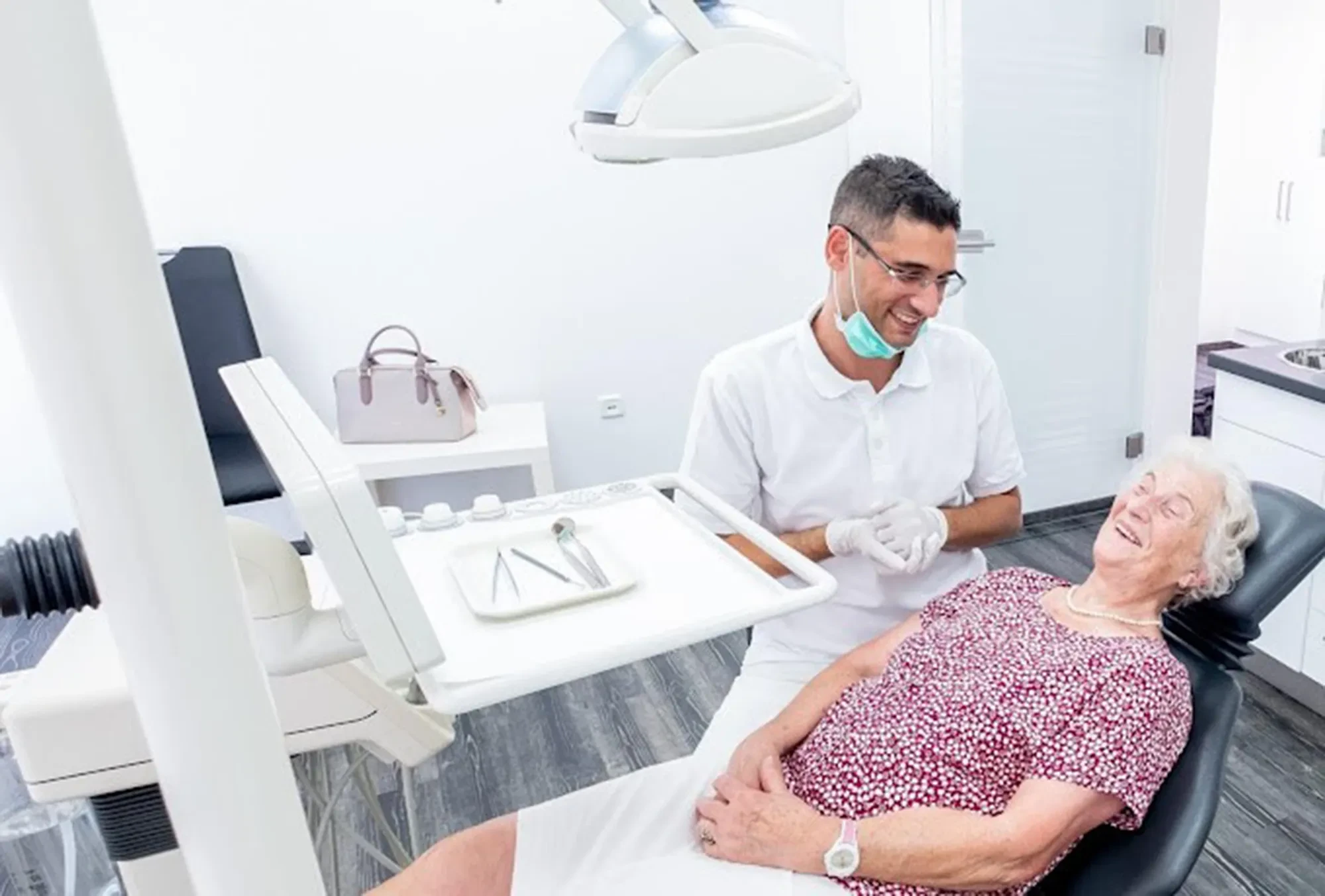 Zahnarzt Dr. Khali bei einer Untersuchung einer Patientin in moderner Praxis