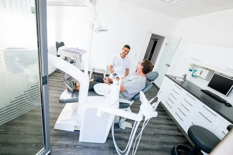 Moderner Behandlungsraum in einer Zahnarztpraxis mit Patient und Zahnarzt