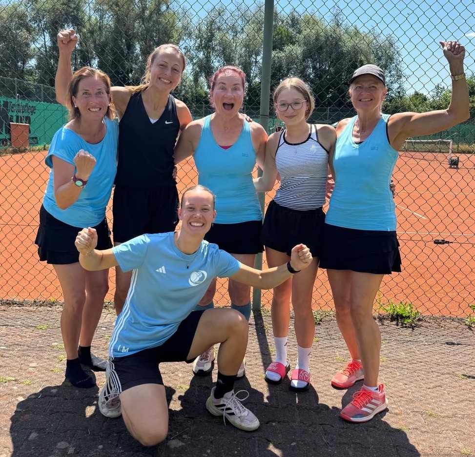 Eine fröhliche Damen-Tennismannschaft feiert ihre erfolgreichen Matches auf dem Tennisplatz.