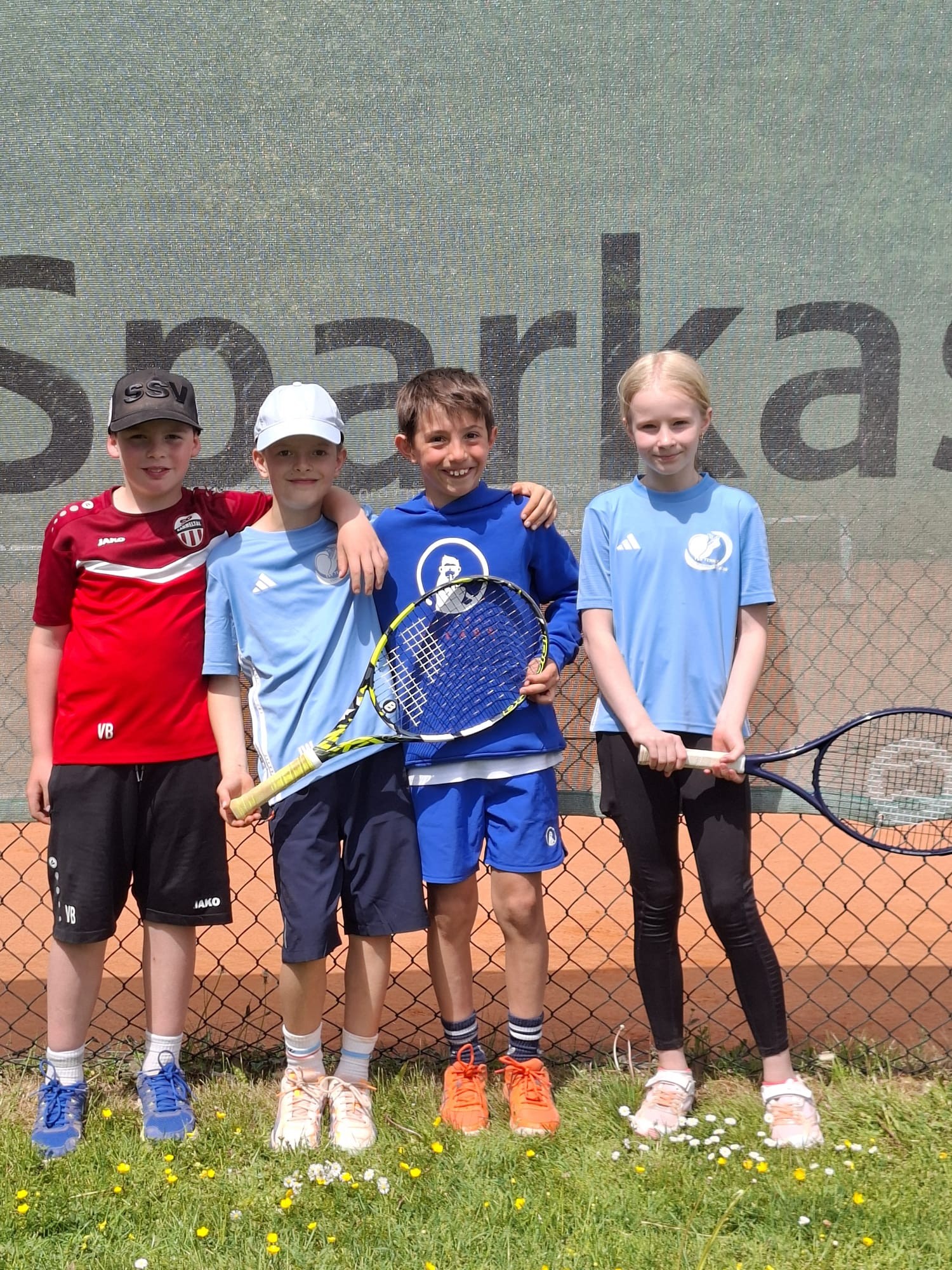 Kinder Tennis Mannschaft vor Sparkasse Banner auf Tennisplatz