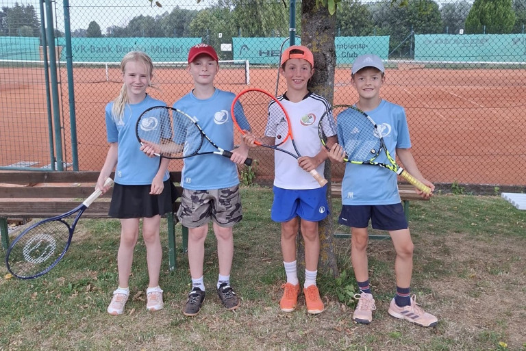 Vier Kinder mit Tennisschlägern auf Tennisplatz beim Bank Bonames Club