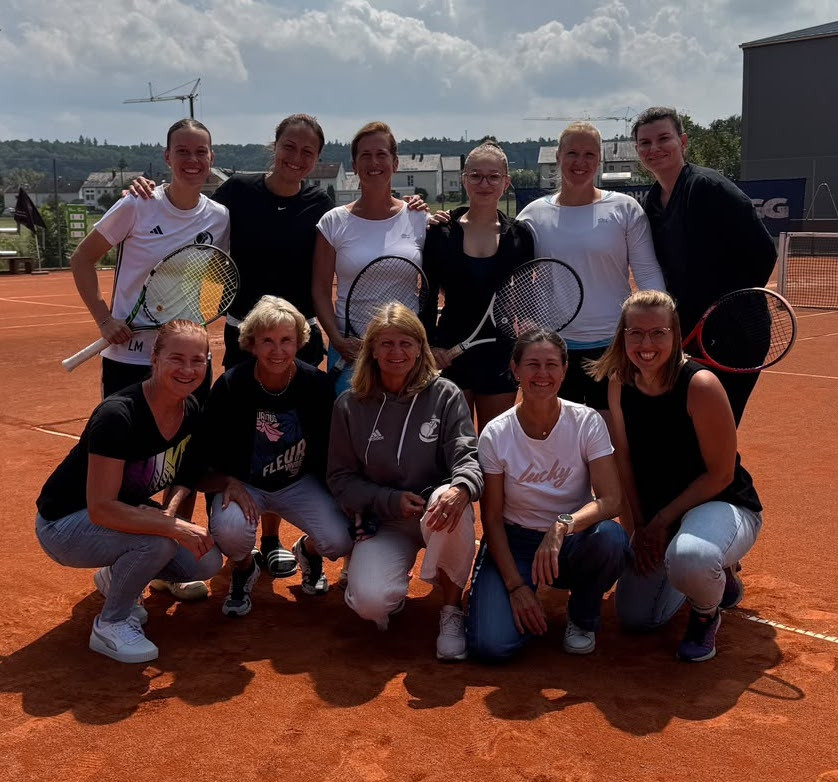 Damen-Tennismannschaft auf Sandplatz beim Gruppenfoto