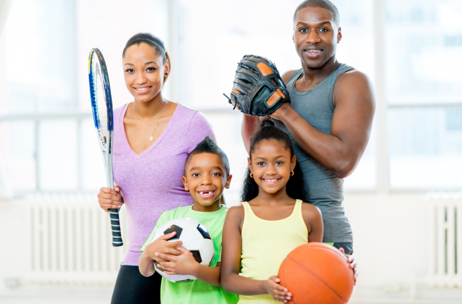 Familie hält Sportausrüstung für Tennis, Fußball, Basketball und Baseball.