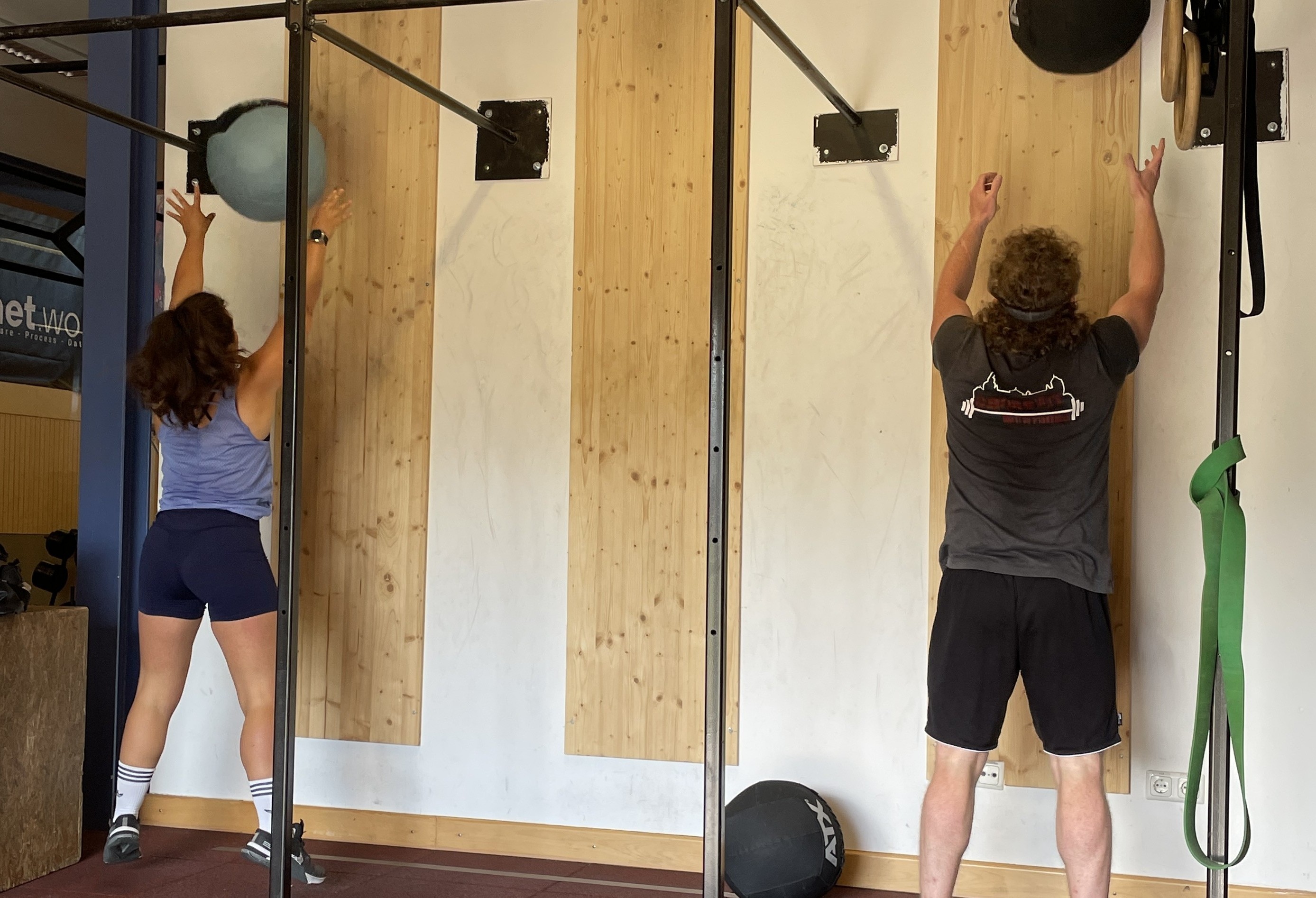 Zwei Personen beim Wall Ball Training im Fitnessstudio