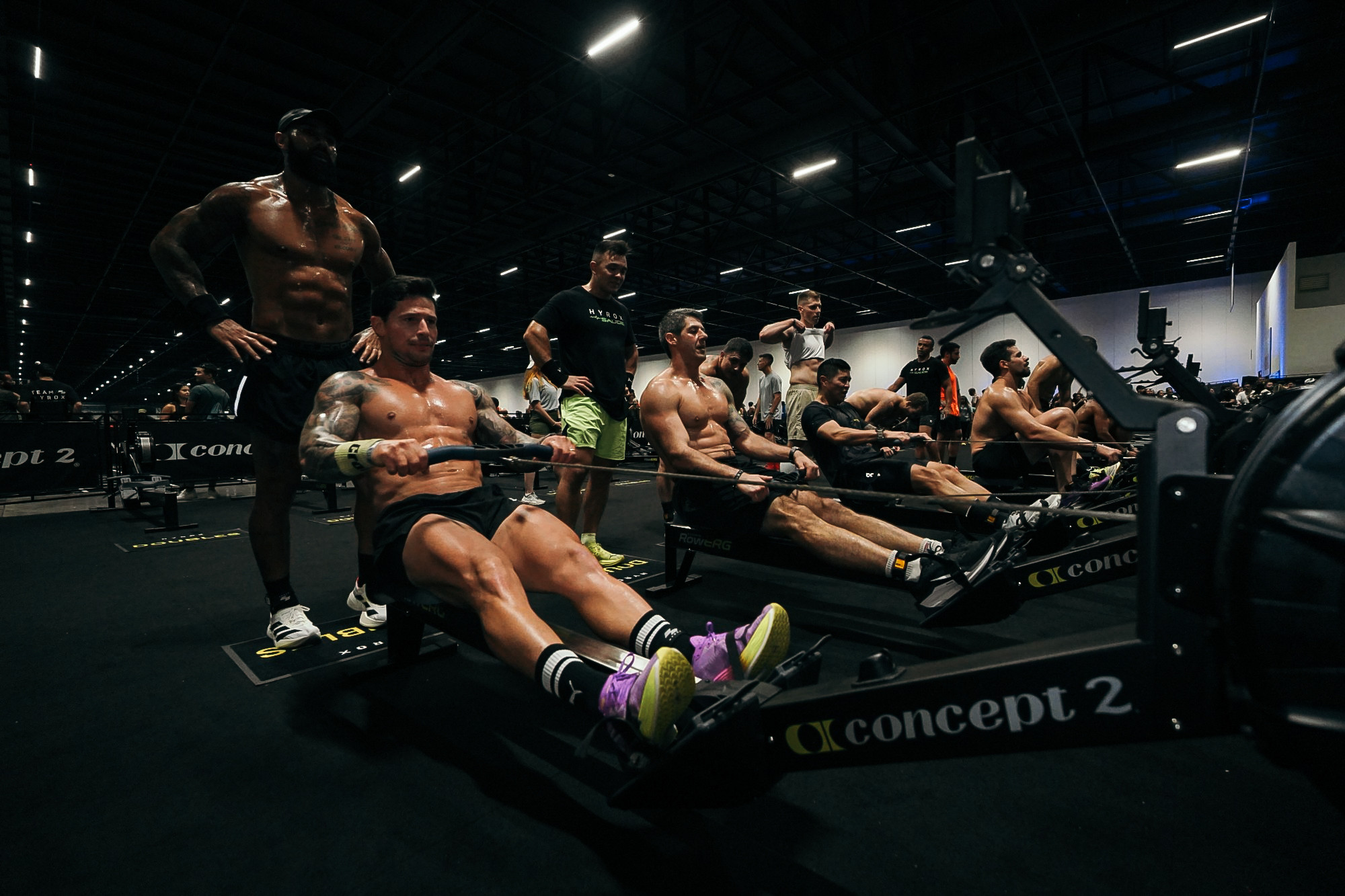 Athleten beim Indoor-Rudern auf Concept2 Rudergeräten während eines Fitnesswettkampfs