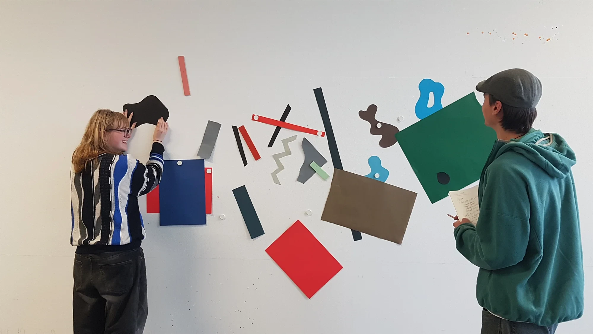 Kreative Gestaltung mit farbigen Papierformen an einer Wand – Beitrag setzen, stellen, legen