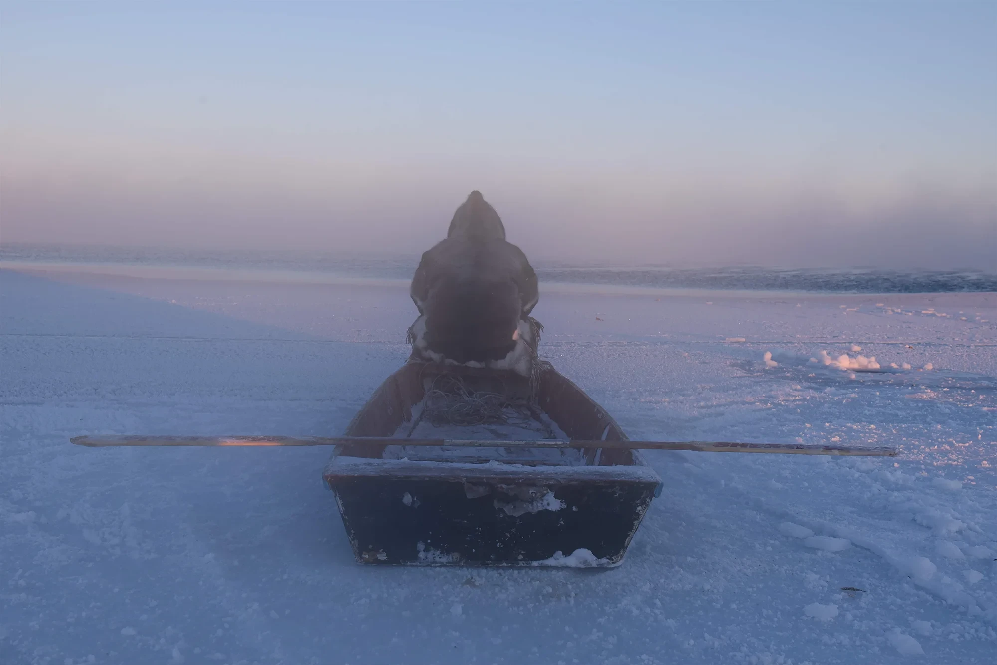 Joar Nango auf einem Boot im verschneiten, eisigen Landschaftspanorama