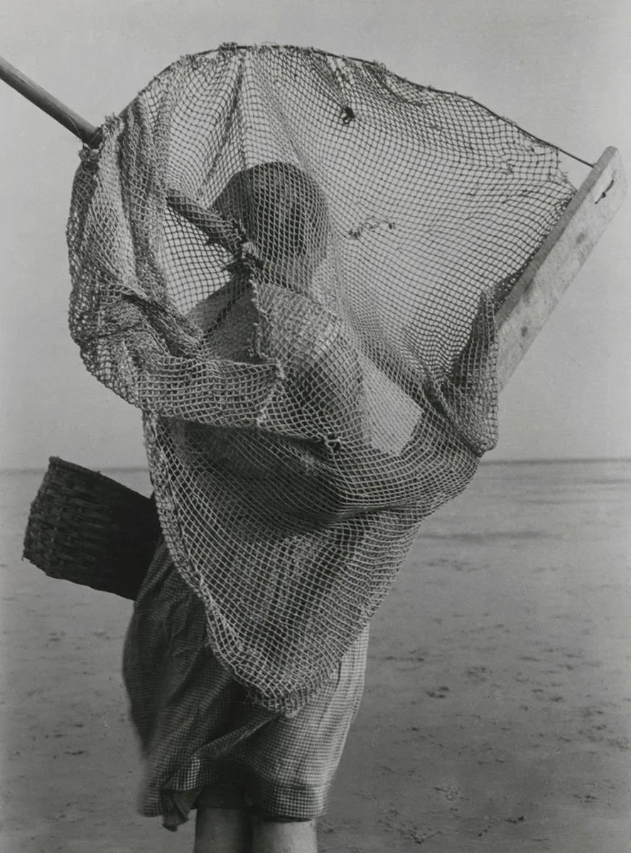 Schwarz-weiß Fotografie aus dem Archiv: Moderne Darstellung einer Person mit Fischernetz am Strand