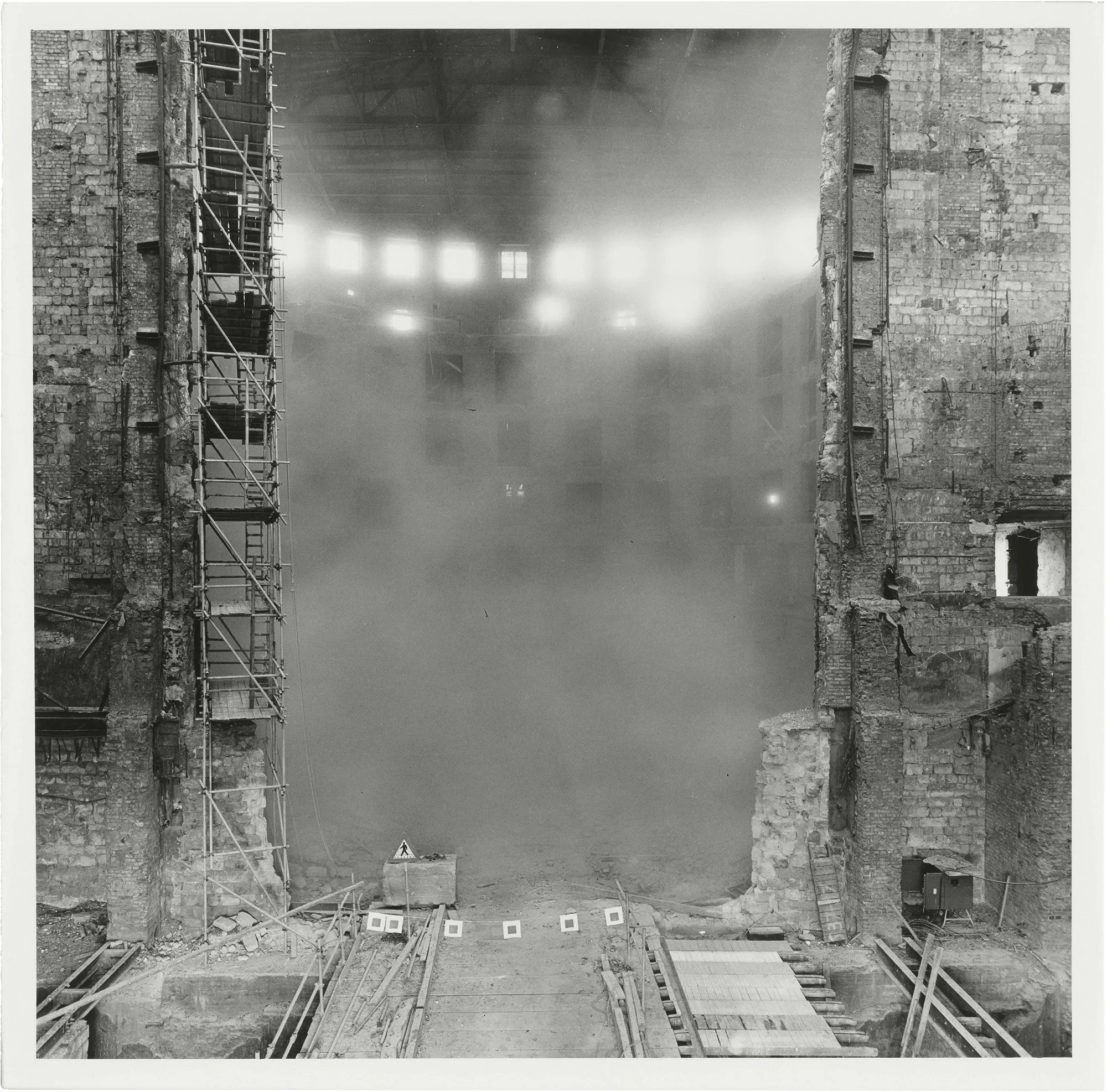 Schwarzweiß-Fotografie von Christian Borchert: Baustelle mit Staub und Gerüst in einem alten Industriegebäude