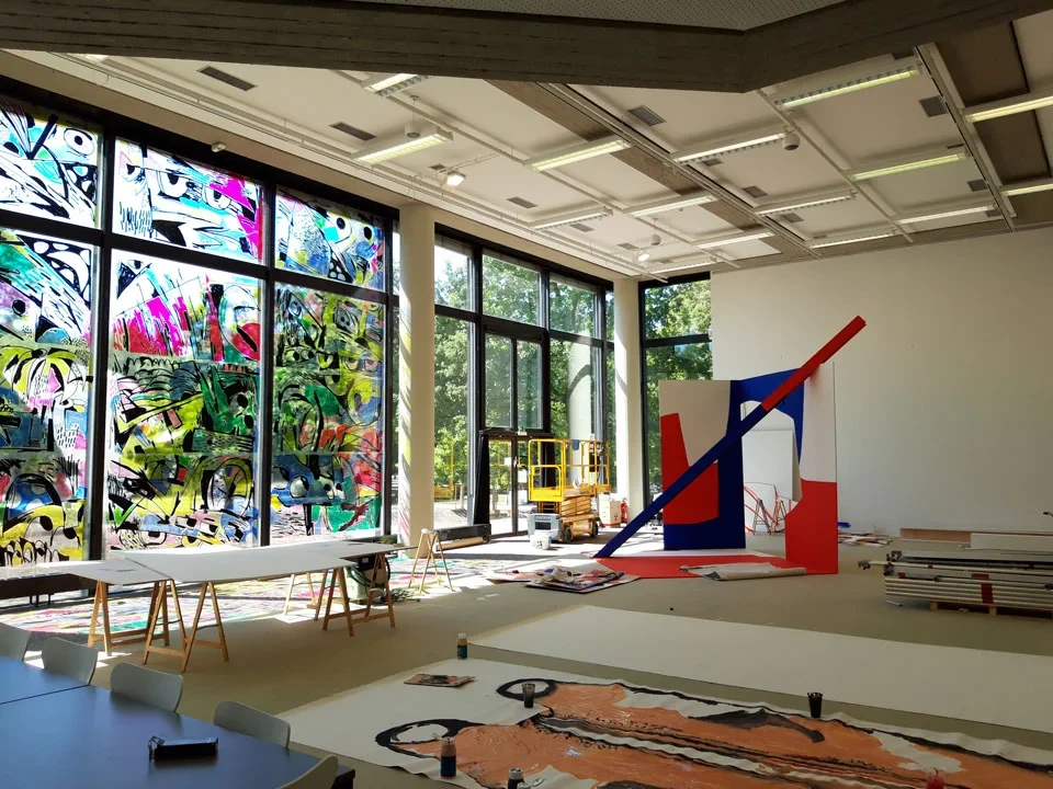 Künstleratelier mit großem Fenster, buntem Graffiti, moderner Skulptur und Malutensilien – beitrag archiviert generator