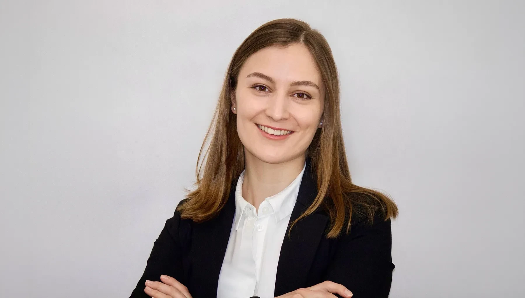 Professionelles Bewerbungsbild einer jungen Frau im Business-Outfit vor hellem Hintergrund