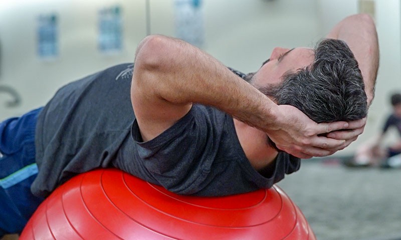 Prostata Hilfe Deutschland: Illustrationsbild Physiotherapie - Mann macht Übungen auf Gymnastikball.