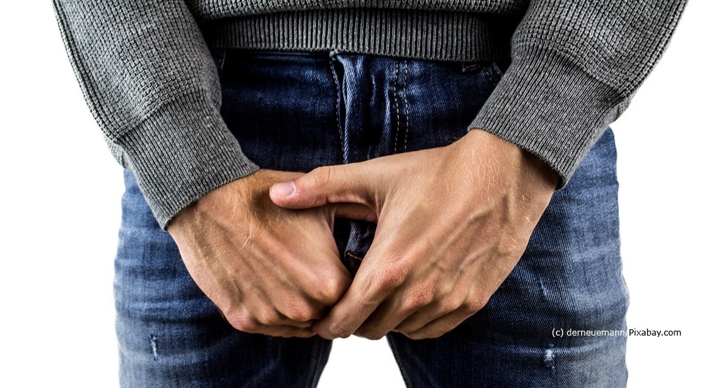 Prostata Hilfe Deutschland: Illustrationsbild - Mann in Jeans hält sich Hände vor den Unterleib.