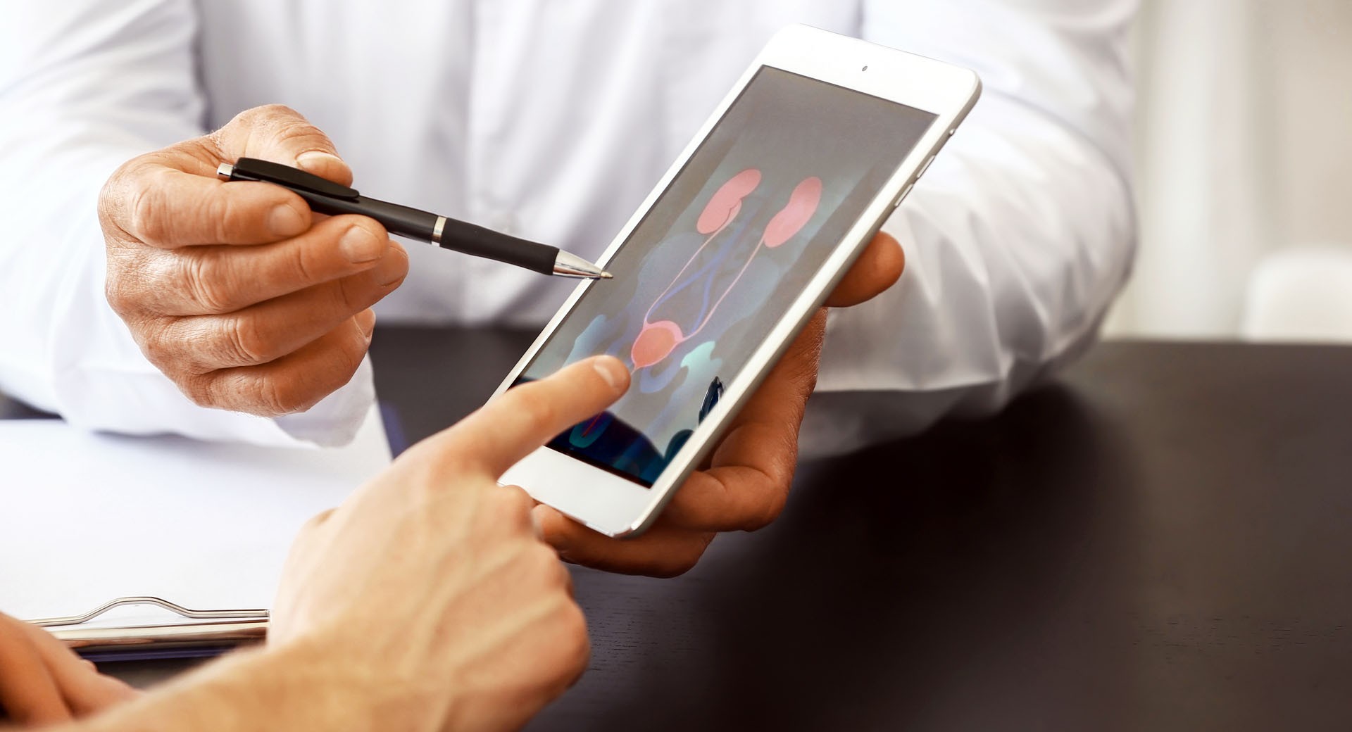 Prostata Hilfe Deutschland: Arzt mit Tablet im Gespräch mit Patient