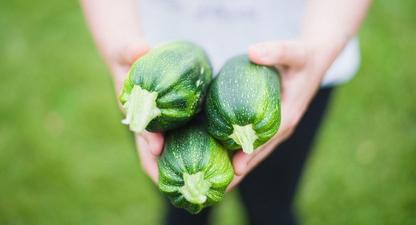 Prostata Hilfe Deutschland: Frau hält drei Zucchini in der Hand.