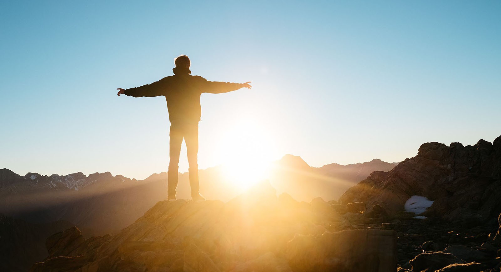 Prostata Hilfe Deutschland: Mann steht in der Sonne auf dem Berg