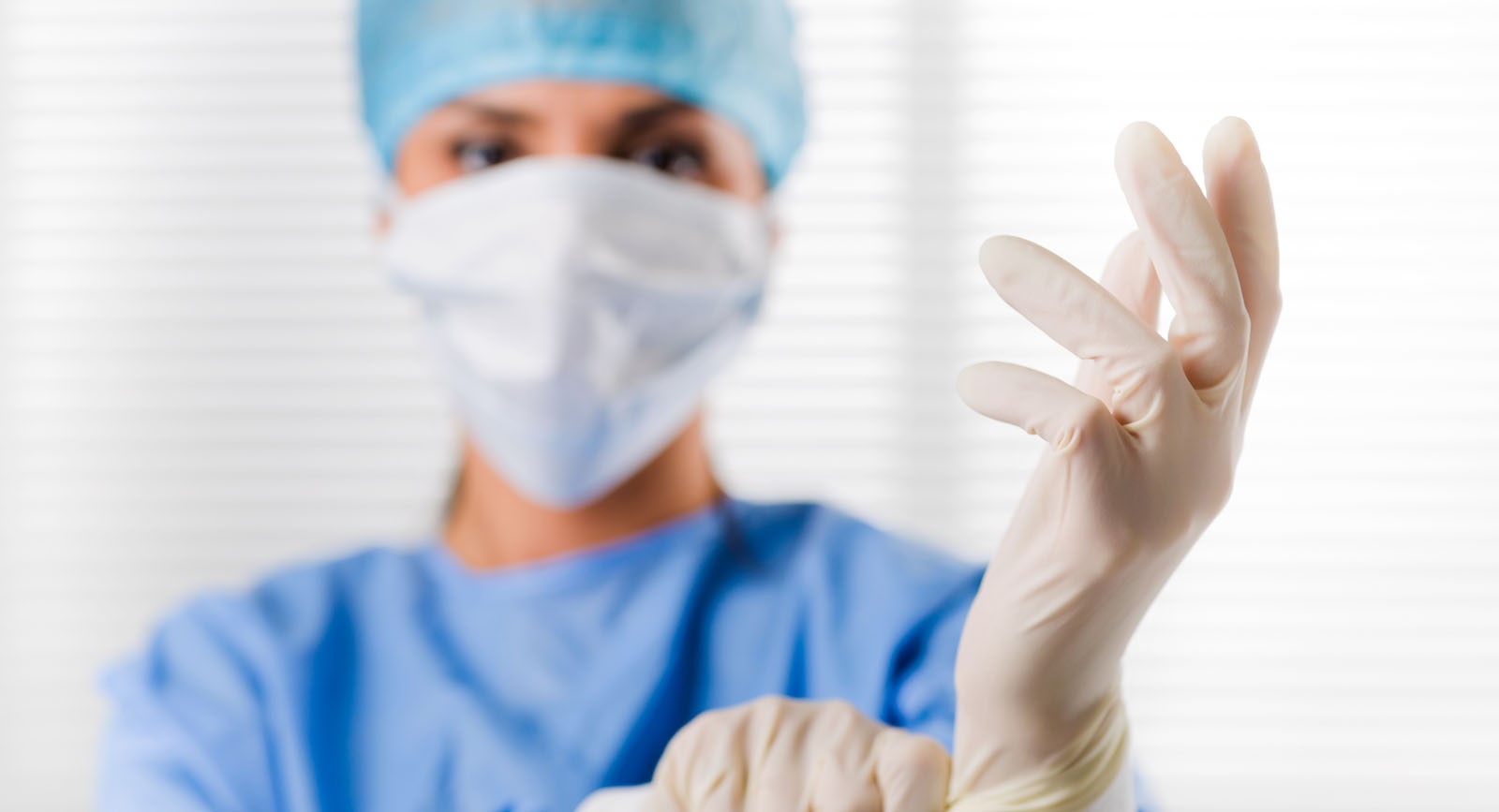 Prostata Hilfe Deutschland: Ärztin zieht sich Handschuhe an